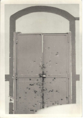 Bullet holes in a gate to a friend's home in Rivas during the Sandinista Revolution, 1978-1979.