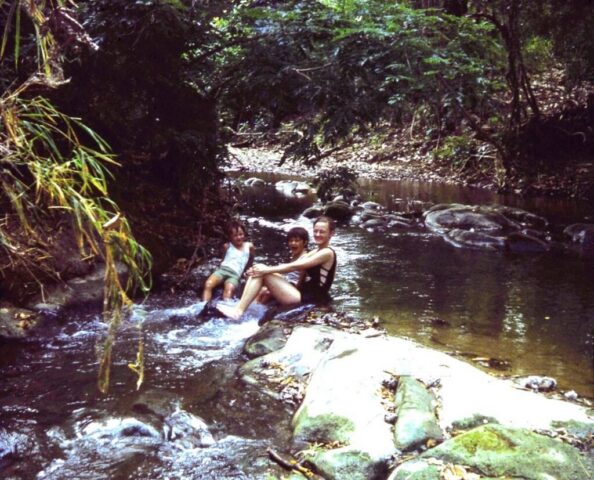 Judy, James, and Fred play in a creek at the campamento, 1974. ©KMC
