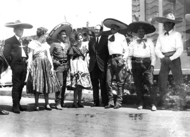 Kennedy M Crockett stands with a group of men and women Mariachi in Tijuana, Mexico, 1960. ©KMC