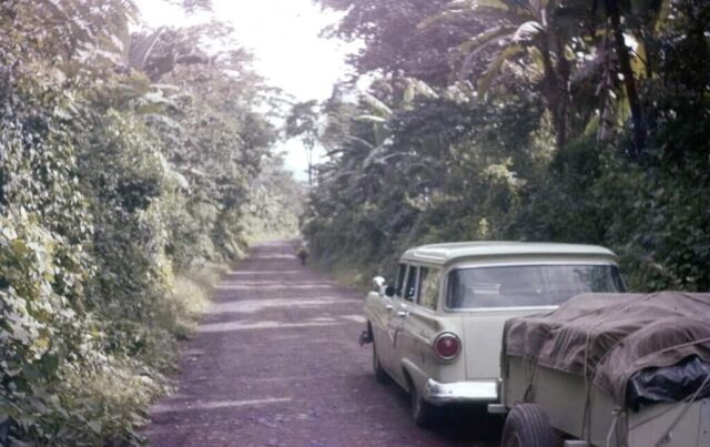 Station wagon and trailer on a dirt Pan-American Highway through the jungle in northern Guatemala, 1960. ©KMC