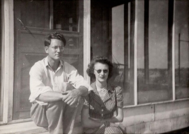A young man and woman sit on steps leading to a screened porch, c 1945. ©KMC