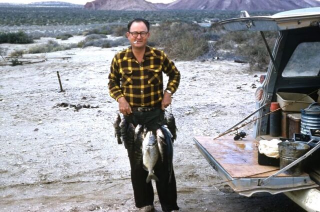 Kennedy M Crockett, Consul General, Tijuana, México, stands holding a string of freshly caught fish during his Baja California expedition, 1961. ©KMC