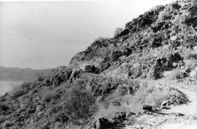 A black and white photo of the carryall navigating a steep, narrow, rugged mountainside road in Baja California, 1961. ©KMC