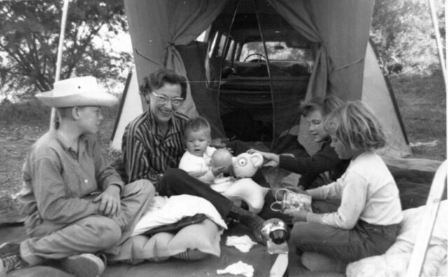 A family gather together under a tarp to celebrate a birthday out in the country near Cabañas, Guatemala, 1958.