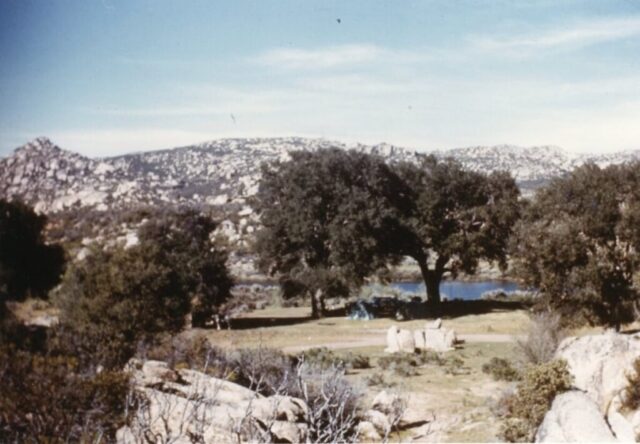 A tent campsite under a grove of trees surrounded by rocky hills among Juan Rodriguez’ bass ponds at Rancho Hechicera, Baja California, 1961. ©KMC