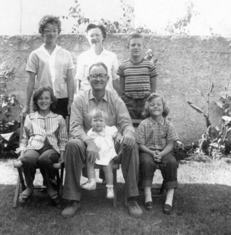 Five kids ranging in age pose with their parents in their backyard in Guatemala, c 1960. ©KMC